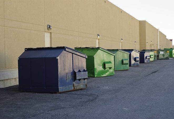 large construction dumpster positioned on a city street in Commack